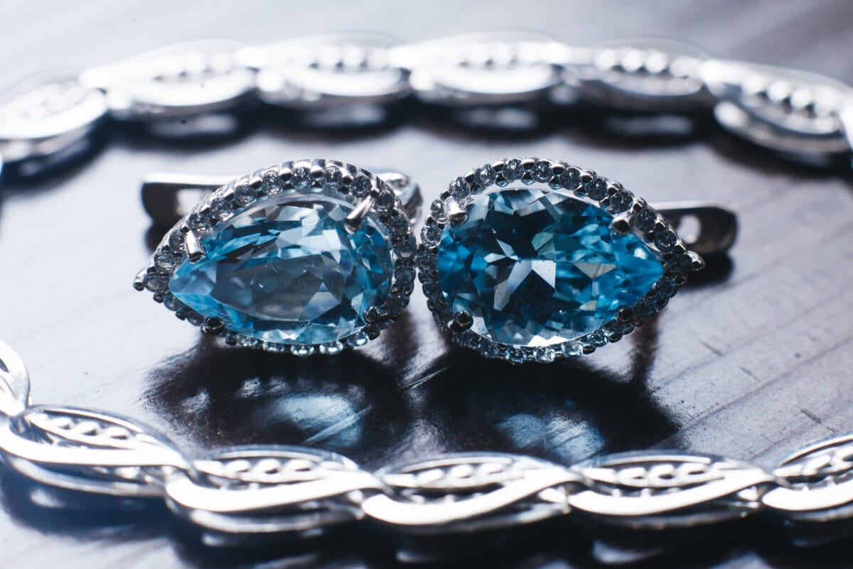 Teardrop Blue Gemstone Earrings with Halo Diamond Jewelry Design on Silver Background