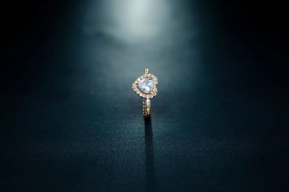 Heart-shaped gold band with halo-set center stone, a luxurious piece of diamond ring jewellery designed for modern elegance.