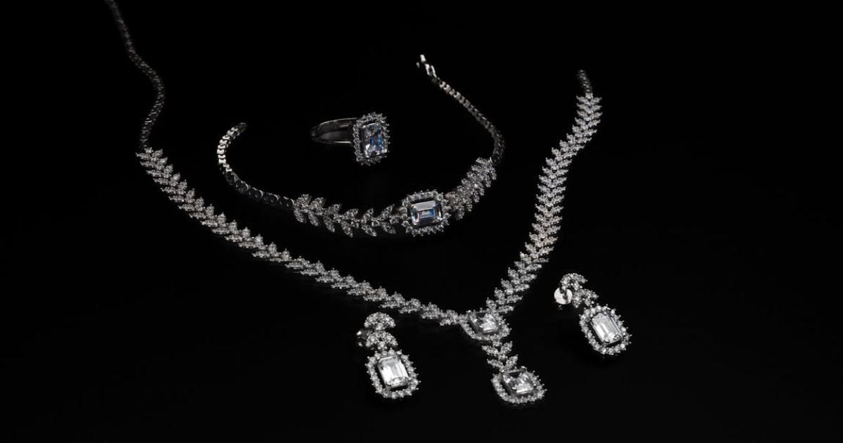 Luxury diamond jewellery set with necklace, bracelet, ring, and earrings displayed on black background