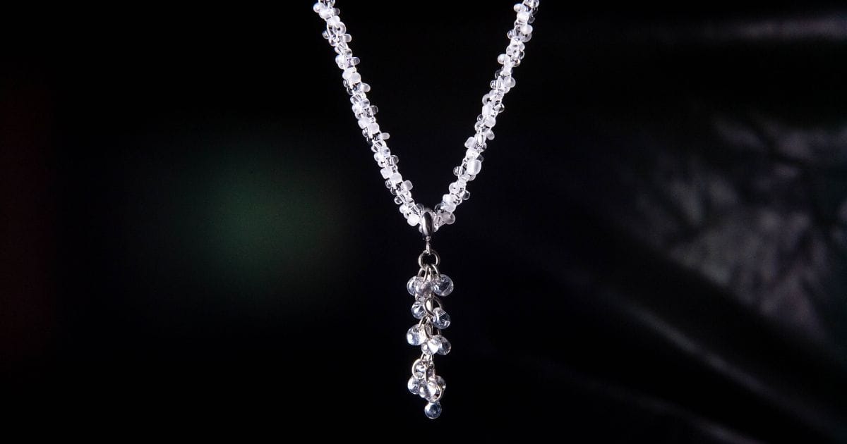 Beaded diamond pendant necklace with a dangling cluster design on a dark background for daily elegance