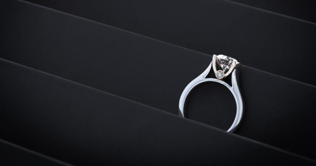Close-up of a stylish diamond ring with unique setting on black background for elegant presentation