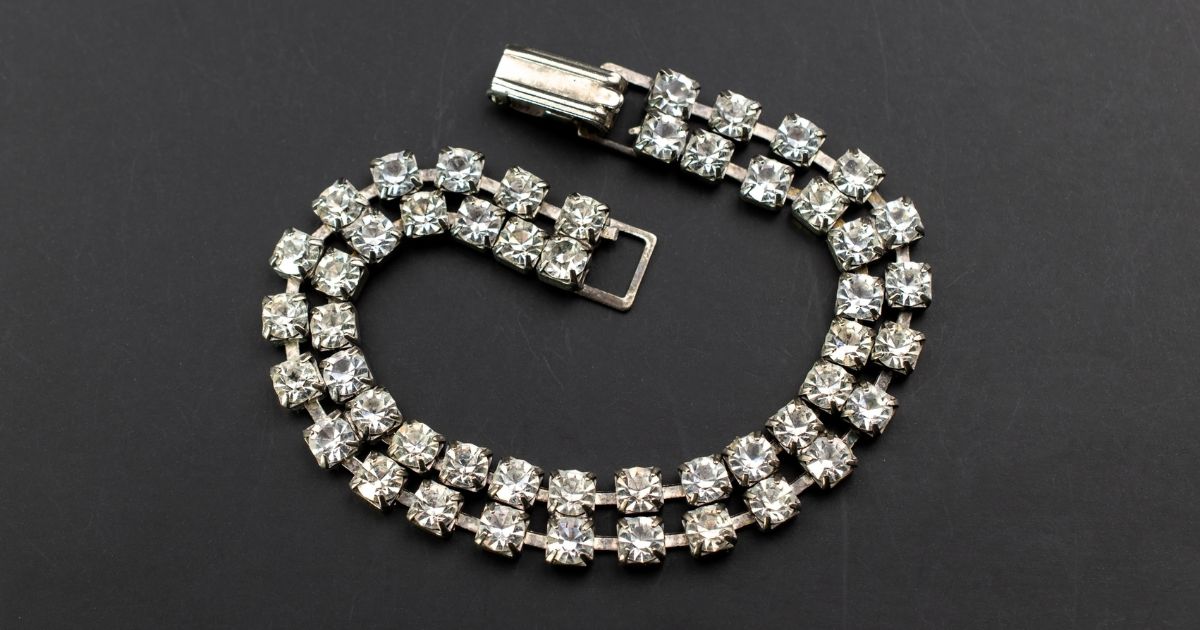 Close-up of a double-row diamond bracelet with sparkling stones on a black background